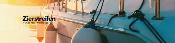 Weißes Segelschiff mit Fendern und Zierstreifen bei Sonnenuntergang. Eine Verlinkung auf diesem Bild führt direkt zur Kategorie Zierstreifen.